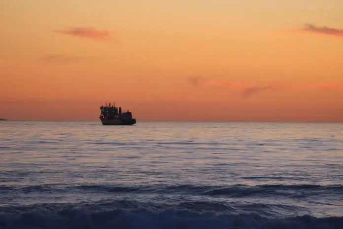 A vessel on the horizon at sunset